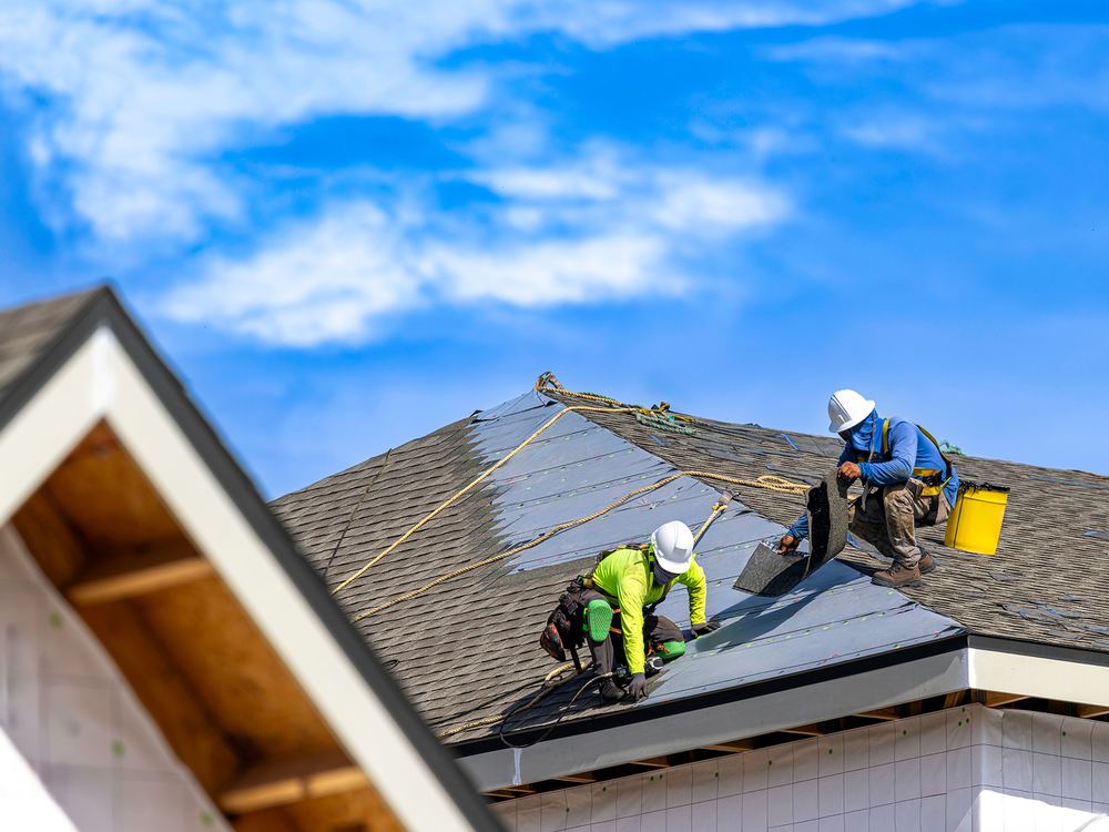 Richmond Roofing crew installing new shingles on a steep roof