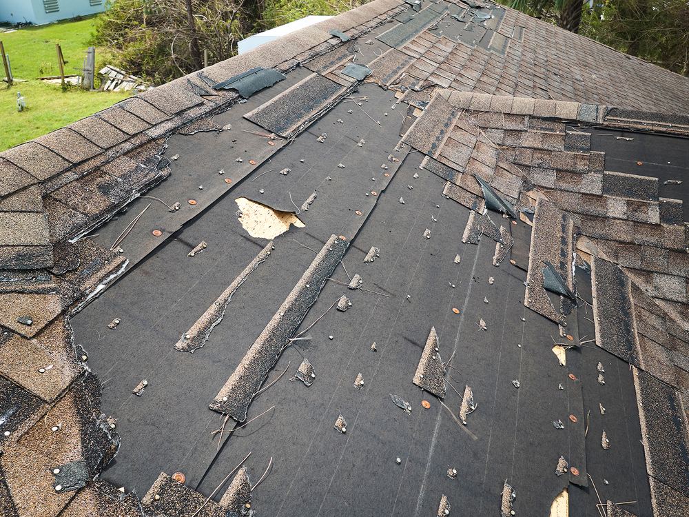 Old shingles stripped back during a full roof tear-off